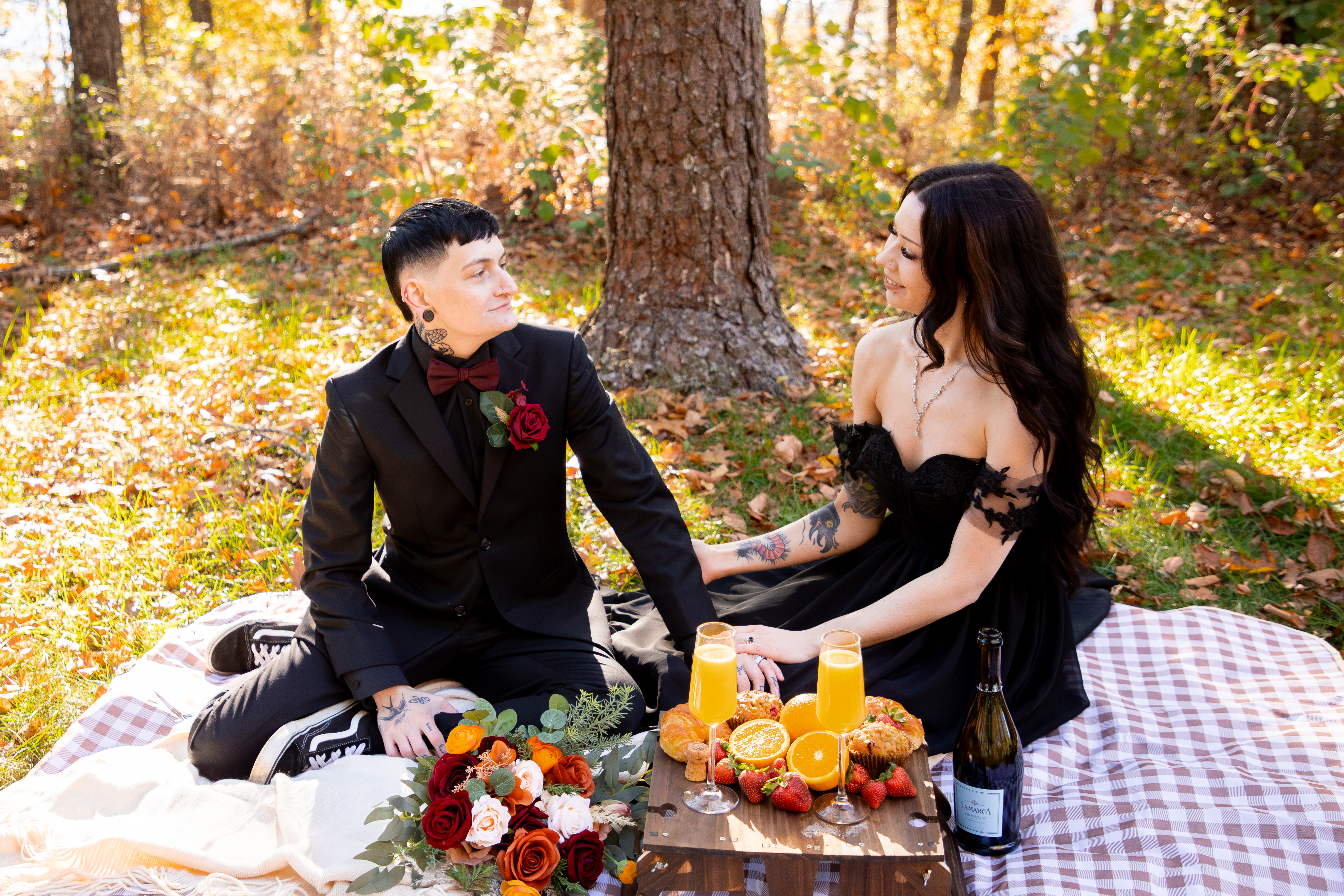 Couple in elopement attire enjoying a styled luxury picnic with florals, mimosas, and charcuterie in Shenandoah National Park