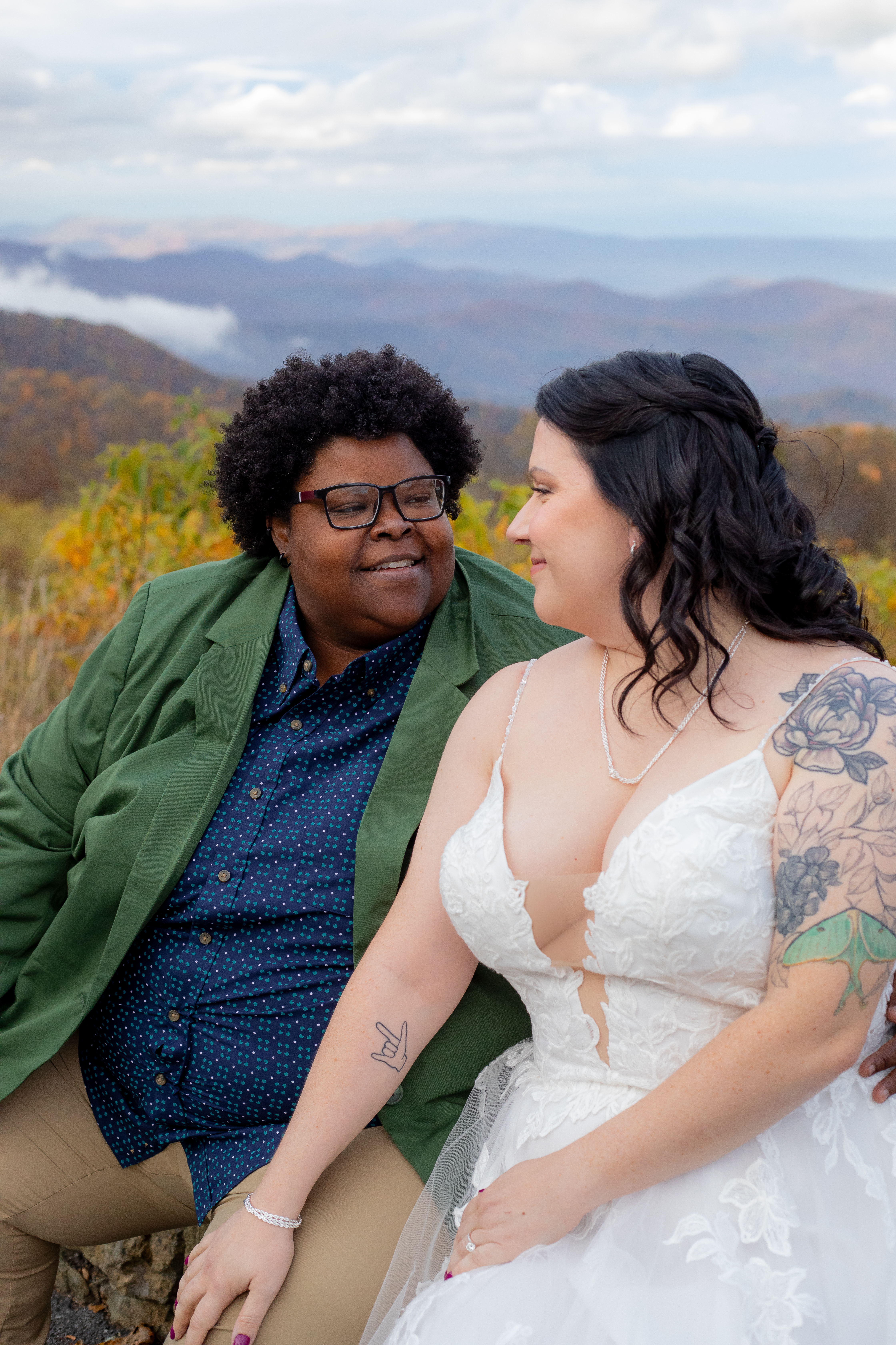 Couple sitting together at a Shenandoah overlook with fall foliage and mountain views