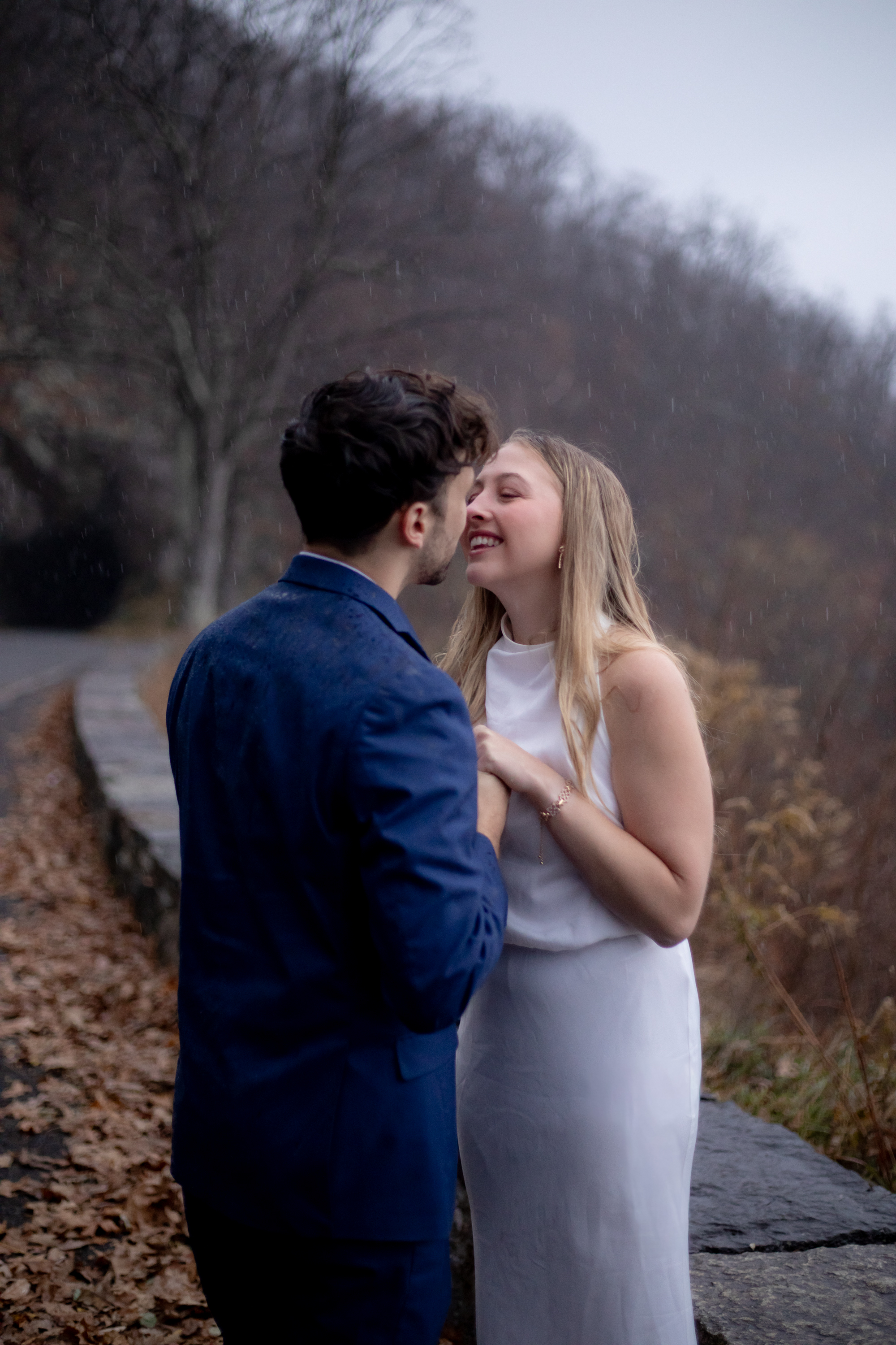Couple laughing together in the rain on Skyline Drive, Shenandoah National Park, rain visible falling around them